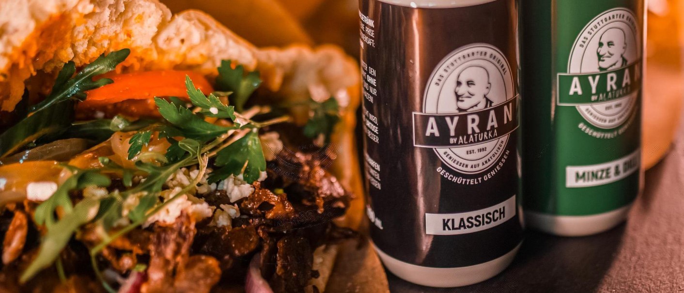 Nahaufnahme eines Döners mit Gemüse und zwei Ayran-Getränken von Alaturka, klassisch und Minze & Dill., © ALATURKA | Das Stuttgarter Original