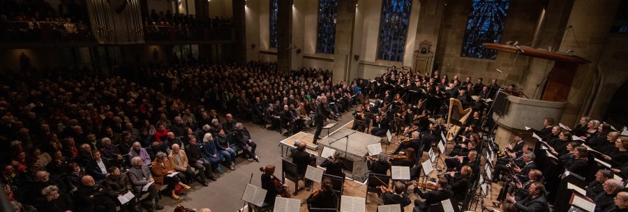 An orchestra and choir perform in a church in front of a large audience. The church has high windows and an organ., &copy; www.hassfoto.de