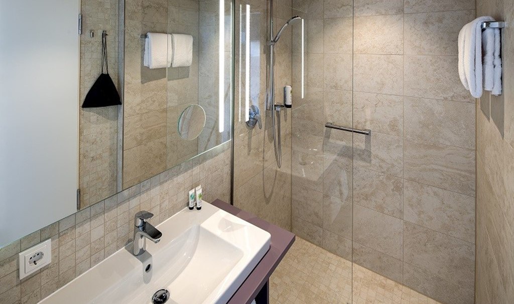 Modern bathroom with large mirror, washbasin, glass shower and towels on the wall., © Hotel am Remspark Modern bathroom with large mirror, washbasin, glass shower and towels on the wall., © Hotel am Remspark