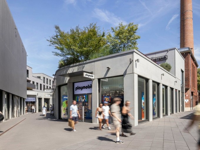 Einkaufsstraße in Metzingen mit einem Playmobil-Geschäft. Menschen gehen vorbei, im Hintergrund ist ein Schornstein zu sehen., © Schlienz-Tours GmbH & Co.KG Einkaufsstraße in Metzingen mit einem Playmobil-Geschäft. Menschen gehen vorbei, im Hintergrund ist ein Schornstein zu sehen., © Schlienz-Tours GmbH & Co.KG
