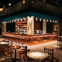 Stylish bar with copper counter, hanging glass globe lights and cozy seating areas. Modern furnishings with warm lighting and decorative elements., &copy; &copy; Ruby Hotels