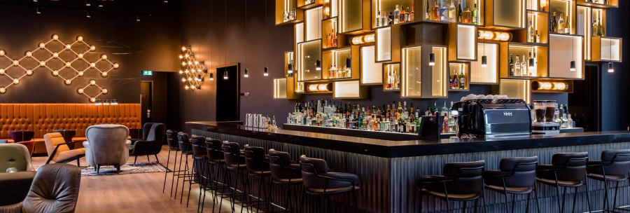 Elegante Bar mit stilvoller Beleuchtung, modernen Sitzgelegenheiten und einer gut bestückten Theke in einem schicken Ambiente., © TOMAS Elegante Bar mit stilvoller Beleuchtung, modernen Sitzgelegenheiten und einer gut bestückten Theke in einem schicken Ambiente., © TOMAS