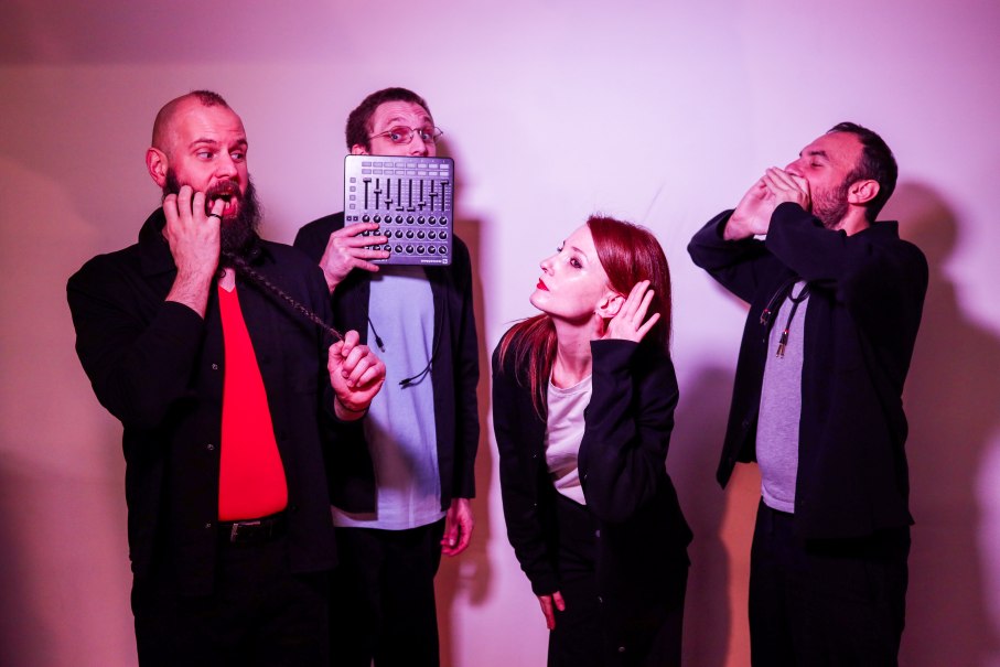 Vier Personen in einer humorvollen Szene: eine h&auml;lt ein Audioger&auml;t, eine andere tut so, als ob sie zuh&ouml;rt, w&auml;hrend die anderen Grimassen schneiden., &copy; Aaron Giordani