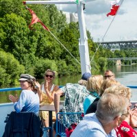 People enjoying a boat trip on the Neckar. They are sitting on the deck, surrounded by green countryside and chatting happily., © all copyrights are reserved by maks richter People enjoying a boat trip on the Neckar. They are sitting on the deck, surrounded by green countryside and chatting happily., © all copyrights are reserved by maks richter