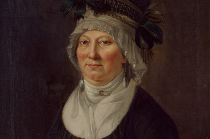 Historisches Portr&auml;t einer Frau in traditioneller Kleidung mit aufwendiger Kopfbedeckung und Ohrringen, vor einem dunklen Hintergrund., &copy; Landesmuseum W&uuml;rttemberg
