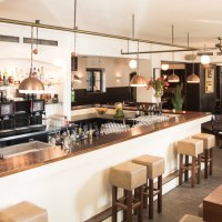 Stylish restaurant with bar, wooden furniture and laid tables. Bright lighting and cozy atmosphere., © Amadeus, Stuttgart Stylish restaurant with bar, wooden furniture and laid tables. Bright lighting and cozy atmosphere., © Amadeus, Stuttgart