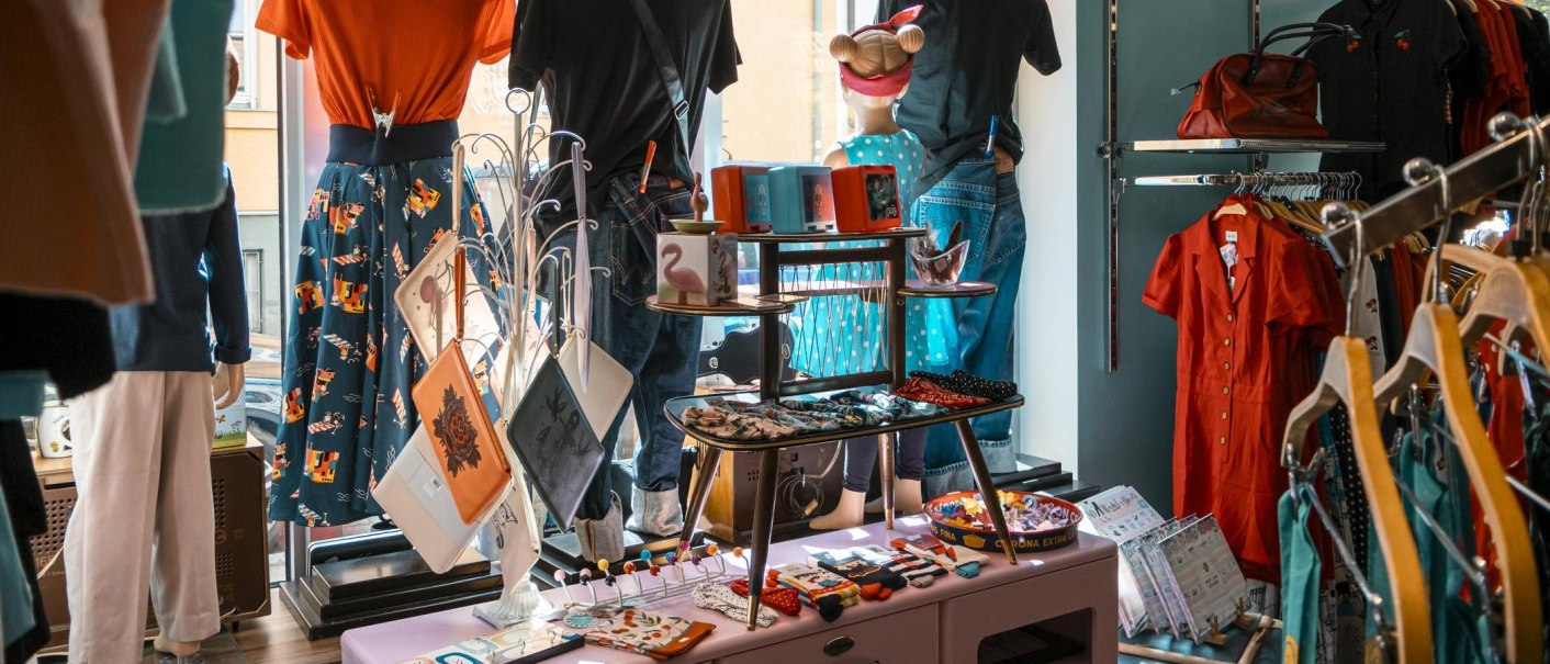 Ein Schaufenster mit Retro-Kleidung und Accessoires. Bunte Kleider, Taschen und Dekorationen sind ausgestellt. Der Stil erinnert an die 50er Jahre., © SMG, Sarah Schmid
