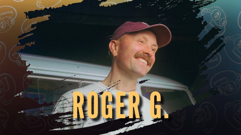 Ein lächelnder Mann mit Schnurrbart und Mütze vor einem grafischen Hintergrund. Der Text 'Roger G.' ist prominent im Bild., © Konzertbüro Schoneberg GmbH
