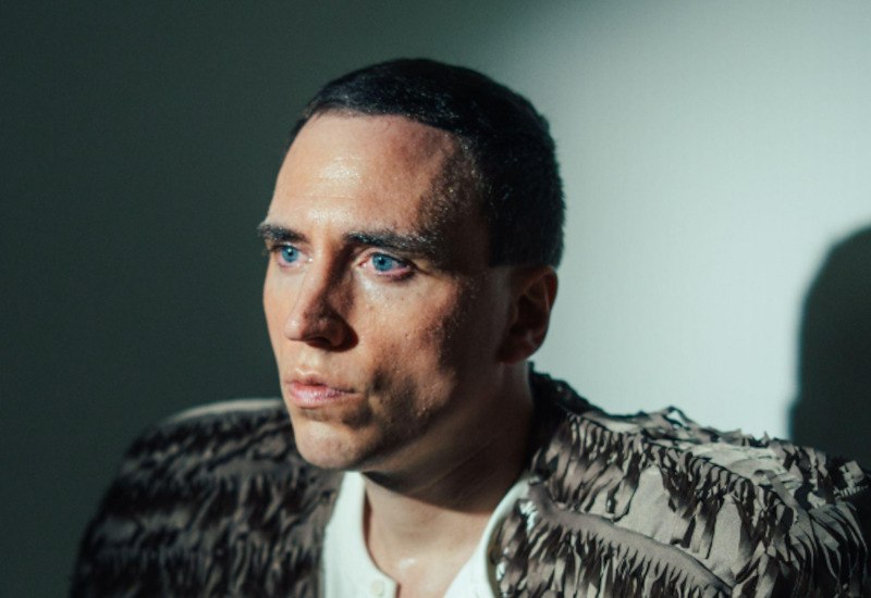 Ein Mann mit kurzem Haar und einem strukturierten Oberteil blickt ernst zur Seite. Die Beleuchtung erzeugt einen dramatischen Schatteneffekt., © Konzertbüro Leipzig Ein Mann mit kurzem Haar und einem strukturierten Oberteil blickt ernst zur Seite. Die Beleuchtung erzeugt einen dramatischen Schatteneffekt., © Konzertbüro Leipzig