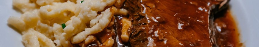 A plate of succulent roast in a dark sauce, served with spaetzle and garnished with chives., © SMG, Thomas Niedermüller
