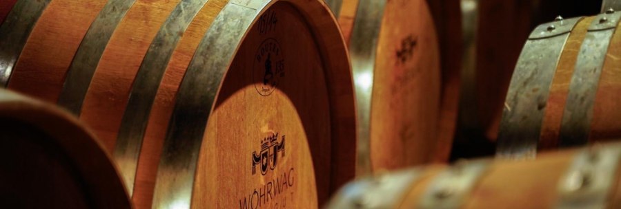 Holzfässer im Barriquekeller des Weinguts Wöhrwag, mit Metallreifen und eingraviertem Logo., © Weingut Wöhrwag Holzfässer im Barriquekeller des Weinguts Wöhrwag, mit Metallreifen und eingraviertem Logo., © Weingut Wöhrwag