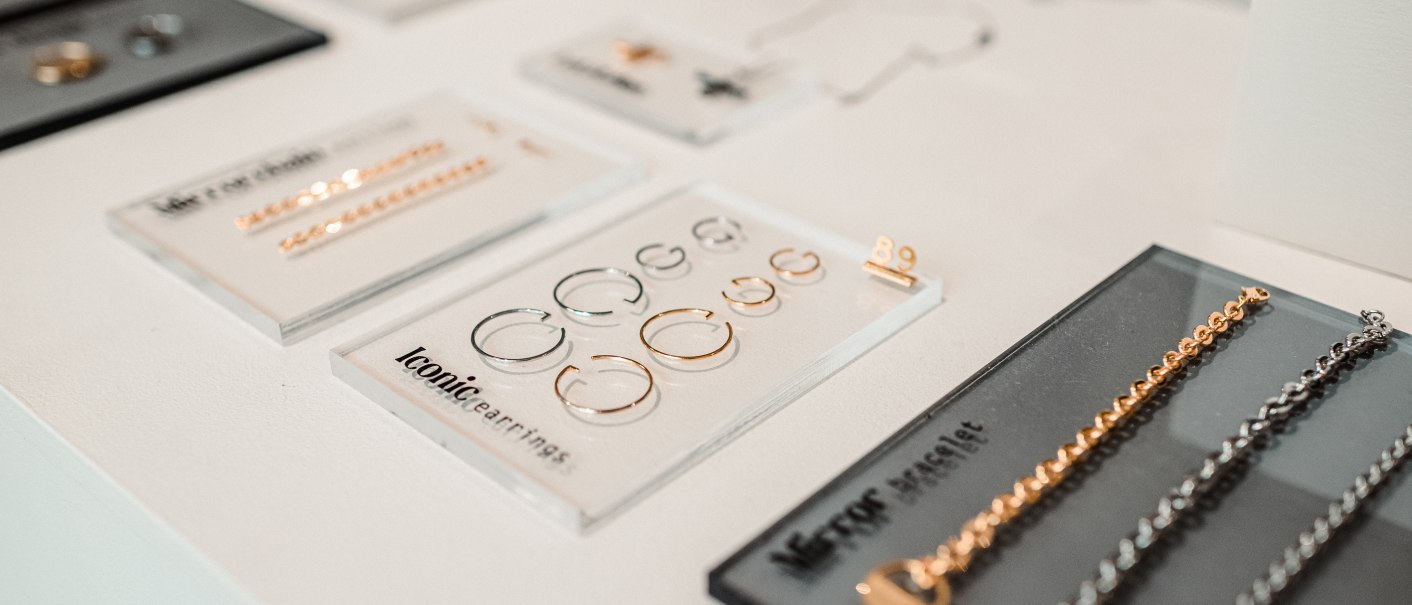 Close-up of jewelry on a table, including gold and silver earrings and bracelets on black and white cards., © Goldmarlen Close-up of jewelry on a table, including gold and silver earrings and bracelets on black and white cards., © Goldmarlen