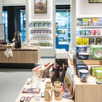 Modern souvenir shop with wooden shelves filled with books, mugs and regional products. Large windows offer a view outside., &copy; Stuttgart-Marketing GmbH, Sarah Schmid
