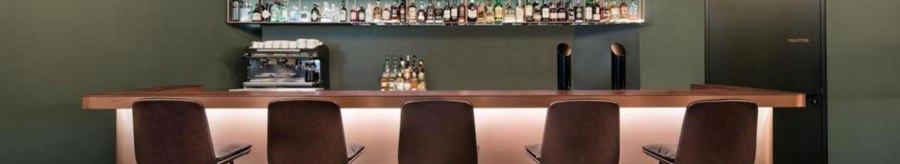 Modern bar with high stools, illuminated counter and bottle rack in the background. Subtle lighting and simple furnishings., © Eduards Bar, Stuttgart Modern bar with high stools, illuminated counter and bottle rack in the background. Subtle lighting and simple furnishings., © Eduards Bar, Stuttgart