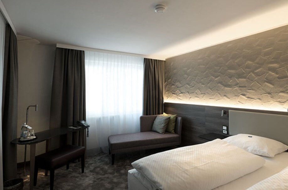 Modernes Hotelzimmer mit Doppelbett, Sofa, Schreibtisch und stilvoller Beleuchtung. Neutrale Farben und gemütliche Atmosphäre., © Hotel am Park Modernes Hotelzimmer mit Doppelbett, Sofa, Schreibtisch und stilvoller Beleuchtung. Neutrale Farben und gemütliche Atmosphäre., © Hotel am Park