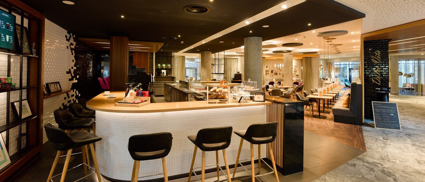 Modern café with bar, stylish seating and inviting atmosphere. Bright lighting and elegant furnishings dominate the room., © Holiday Inn Stuttgart Modern café with bar, stylish seating and inviting atmosphere. Bright lighting and elegant furnishings dominate the room., © Holiday Inn Stuttgart