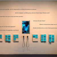 Ausstellungswand mit Fragen zur Polizei und Bürgerrechten, Notizen und Kopfhörern. Besucher können ihre Gedanken aufschreiben und anhören., © Haus der Geschichte Baden-Württemberg Ausstellungswand mit Fragen zur Polizei und Bürgerrechten, Notizen und Kopfhörern. Besucher können ihre Gedanken aufschreiben und anhören., © Haus der Geschichte Baden-Württemberg