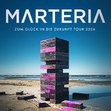 Black and pink blocks are piled up on the beach, above them the lettering 'MARTERIA - Zum Glück in die Zukunft Tour 2026' against a blue sky., © links im Bild Black and pink blocks are piled up on the beach, above them the lettering 'MARTERIA - Zum Glück in die Zukunft Tour 2026' against a blue sky., © links im Bild