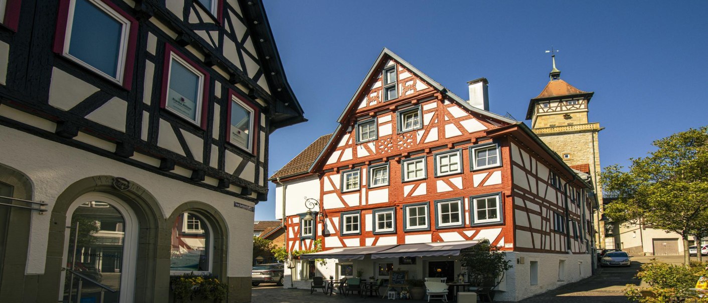 Half-timbered houses in the old town of Waiblingen, Germany, in sunny weather. A tower is visible in the background., © SMG Stuttgart Marketing GmbH - Sarah Schmid