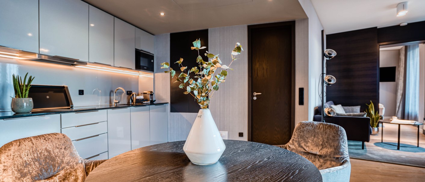 Moderne Suite mit eleganter Küche, rundem Esstisch und gemütlichem Wohnzimmer. Dezente Beleuchtung und stilvolle Dekoration., © CLOUD N°7 APARTMENTS GmbH Moderne Suite mit eleganter Küche, rundem Esstisch und gemütlichem Wohnzimmer. Dezente Beleuchtung und stilvolle Dekoration., © CLOUD N°7 APARTMENTS GmbH