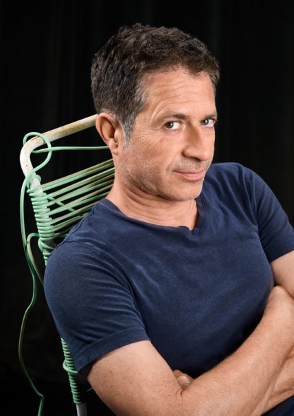 Ein Mann in einem blauen T-Shirt sitzt auf einem gr&uuml;nen Stuhl und blickt selbstbewusst in die Kamera., &copy; Theaterhaus Stuttgart e.V.