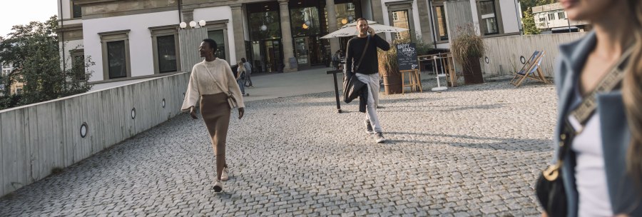 The StadtPalais Stuttgart with a classic façade, people walking on a paved path in front of it. In the background are trees and a sunny sky., © Stuttgart-Marketing GmbH, WP Steinheisser