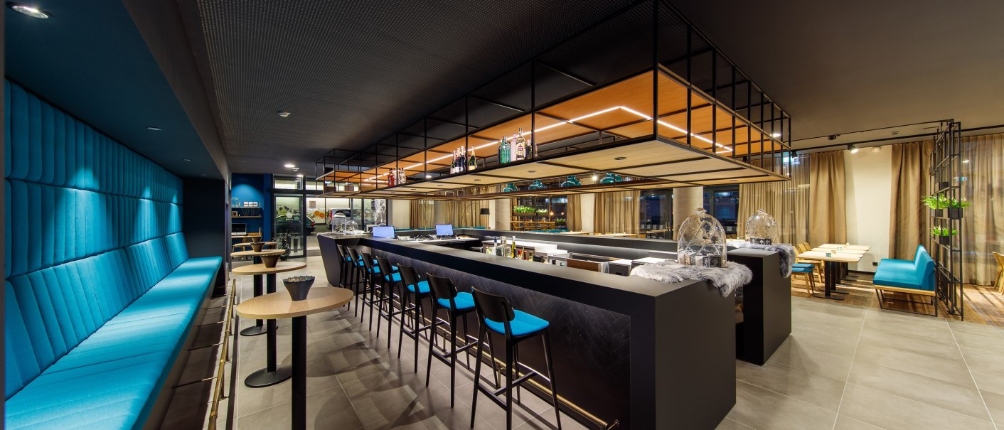 Modern bar with blue benches and stools, stylish lighting and decorative elements. Elegant, minimalist design., © Arthotel ANA Momentum Modern bar with blue benches and stools, stylish lighting and decorative elements. Elegant, minimalist design., © Arthotel ANA Momentum