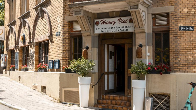 Eingang des Restaurants Huong Viet mit Blumenarrangements und einem E-Scooter auf dem Gehweg., © Stuttgart Marketing GmbH, Sarah Schmid