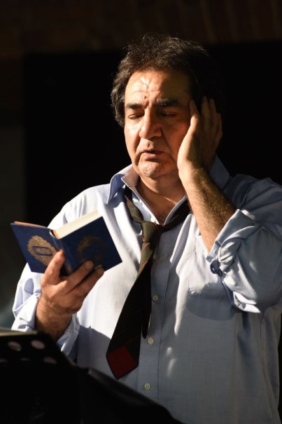 Ein Mann in Hemd und Krawatte liest nachdenklich aus einem kleinen Buch vor, die Hand an der Wange., © Theaterhaus Stuttgart e.V.