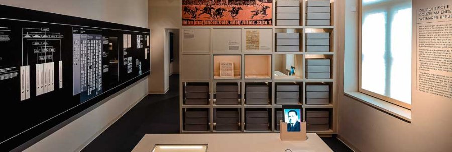 An exhibition room with shelves full of archive boxes, documents on a table and information boards on the walls., © Haus der Geschichte Baden-Württemberg