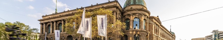 The Haus der Wirtschaft in Stuttgart with its magnificent fa&ccedil;ade and dome, surrounded by flags and green vegetation., &copy; &copy; Stuttgart-Marketing GmbH, Werner Dieterich