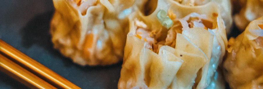Nahaufnahme von ged&auml;mpften Dumplings mit St&auml;bchen auf einem Teller. Die Dumplings sind gef&uuml;llt und haben eine helle, gl&auml;nzende Oberfl&auml;che., &copy; C&auml;ff Chen, Stuttgart