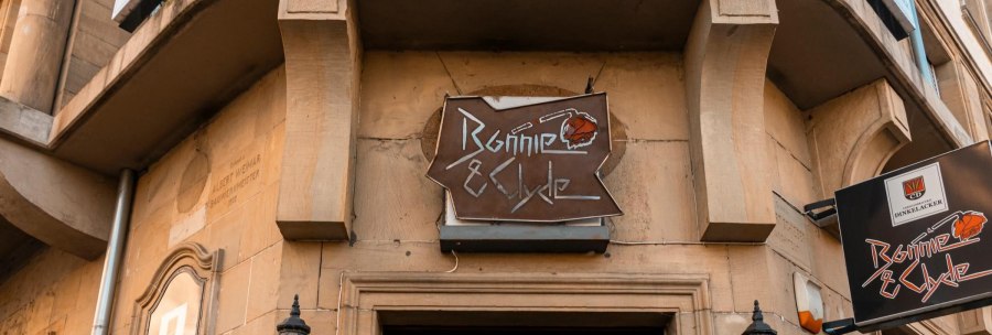 A sign with the inscription 'Bonnie & Clyde' hangs on a building. The fa&ccedil;ade is made of stone and there are decorative lanterns., &copy; SMG Stuttgart Marketing GmbH - Sarah Schmid