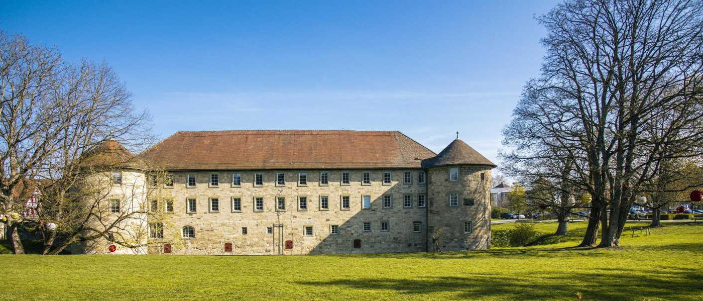 The castle in Schorndorf, surrounded by green meadows and bare trees under a clear blue sky., &copy; SMG Stuttgart Marketing GmbH - Sarah Schmid