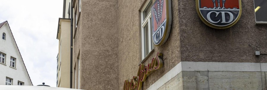 A building with the lettering 'Mrs Jones' and a logo with ears of corn and the letters 'CD'. A parasol is visible in the foreground., &copy; SMG, Sarah Schmid