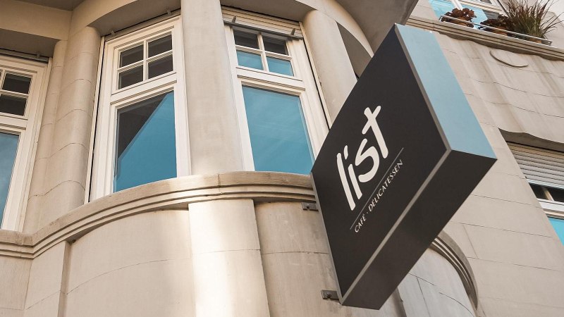 Fassade eines Gebäudes mit großen Fenstern und einem Schild mit der Aufschrift 'list Café Delicatessen'., © Café LIST, Stuttgart Fassade eines Gebäudes mit großen Fenstern und einem Schild mit der Aufschrift 'list Café Delicatessen'., © Café LIST, Stuttgart