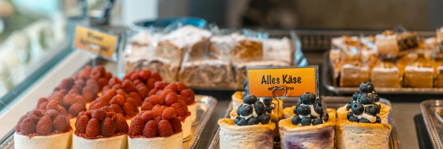 Cake in a display case, decorated with raspberries and blueberries. A sign reading 'All cheese' is visible., &copy; SMG Stuttgart Marketing GmbH - Sarah Schmid