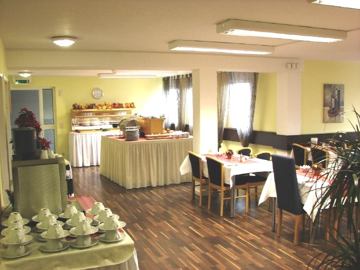 Heller Fr&uuml;hst&uuml;cksraum mit gedeckten Tischen, Buffet im Hintergrund, Holzboden und dekorativen Pflanzen., &copy; Central Hotel
