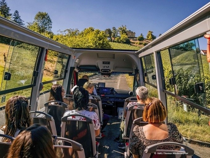 Innenansicht eines Busses auf einer Weintour durch Stuttgart. Passagiere sitzen und genießen den Blick auf die Weinberge., © SMG, Thomas Niedermüller Innenansicht eines Busses auf einer Weintour durch Stuttgart. Passagiere sitzen und genießen den Blick auf die Weinberge., © SMG, Thomas Niedermüller