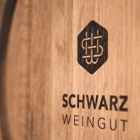 Wooden barrel with the logo and lettering 'Schwarz Weingut', close-up., © Weingut Schwarz Wooden barrel with the logo and lettering 'Schwarz Weingut', close-up., © Weingut Schwarz