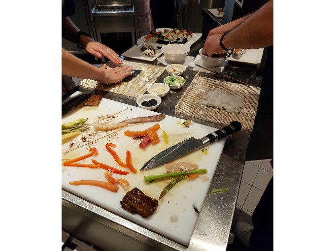 Zwei Personen bereiten Sushi auf einer Arbeitsfläche zu. Verschiedene Zutaten und ein Messer liegen auf einem Schneidebrett., © Kultweine-Kochwelten-Kunstücke - Kochschule Sonja Lenz Zwei Personen bereiten Sushi auf einer Arbeitsfläche zu. Verschiedene Zutaten und ein Messer liegen auf einem Schneidebrett., © Kultweine-Kochwelten-Kunstücke - Kochschule Sonja Lenz