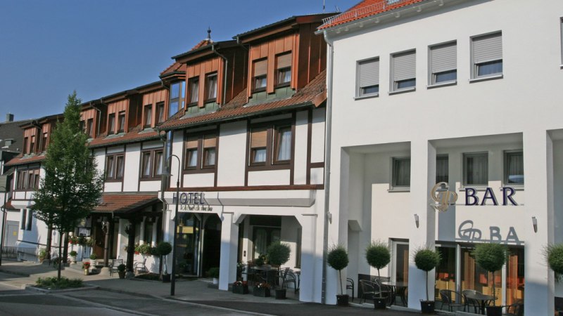 Fachwerkhotel mit moderner Fassade, Hotel Goldener Pflug. Links Bäume, rechts Barbereich mit Sitzgelegenheiten. Sonniger Tag., © Hotel & Restaurant Goldener Pflug Fachwerkhotel mit moderner Fassade, Hotel Goldener Pflug. Links Bäume, rechts Barbereich mit Sitzgelegenheiten. Sonniger Tag., © Hotel & Restaurant Goldener Pflug