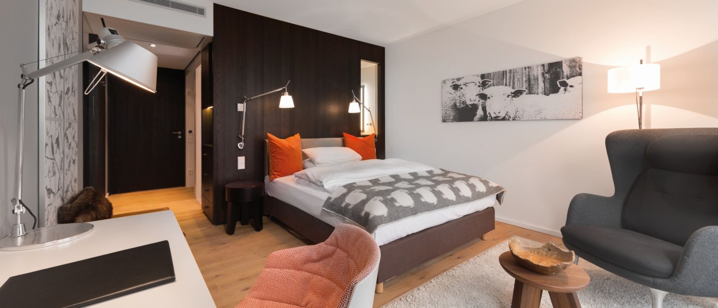 Modernes Hotelzimmer mit Doppelbett, Schreibtisch, Sessel und dekorativem Bild an der Wand. Helle Farben und stilvolle Einrichtung., © Achalm. Hotel GmbH & Co. KG Modernes Hotelzimmer mit Doppelbett, Schreibtisch, Sessel und dekorativem Bild an der Wand. Helle Farben und stilvolle Einrichtung., © Achalm. Hotel GmbH & Co. KG
