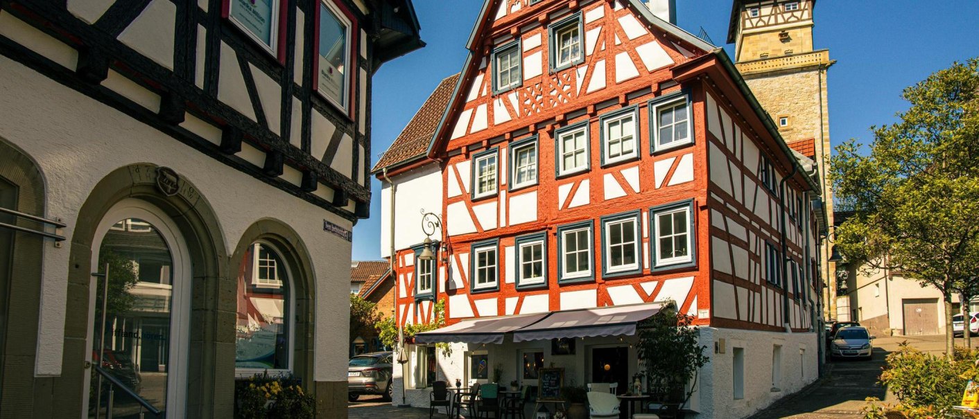 Half-timbered houses in the old town of Waiblingen, with a café in the foreground and a tower in the background, in sunny weather., © Stuttgart-Marketing GmbH, Sarah Schmid Half-timbered houses in the old town of Waiblingen, with a café in the foreground and a tower in the background, in sunny weather., © Stuttgart-Marketing GmbH, Sarah Schmid