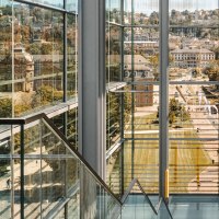 Blick durch moderne Glasarchitektur auf den Schlossplatz. Im Hintergrund historische Gebäude und Menschen. Klare Linien und Reflexionen dominieren das Bild., © Stuttgart-Marketing GmbH, Sarah Schmid Blick durch moderne Glasarchitektur auf den Schlossplatz. Im Hintergrund historische Gebäude und Menschen. Klare Linien und Reflexionen dominieren das Bild., © Stuttgart-Marketing GmbH, Sarah Schmid