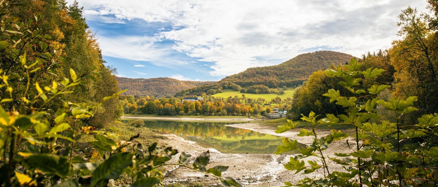 An autumnal landscape at the Glems Reservoir in Metzingen. Colorful trees and hills are reflected in the calm water., &copy; SMG Stuttgart Marketing GmbH - Sarah Schmid