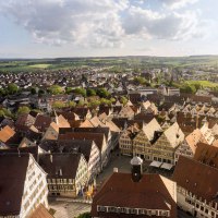 Panorama of a town with many half-timbered houses, surrounded by green countryside and fields under a cloudy sky., © Stuttgart-Marketing GmbH, Martina Denker