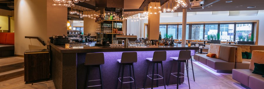 Modern bar with stylish lighting, high stools and cozy seating areas. The atmosphere is inviting and elegant., &copy; Breuninger