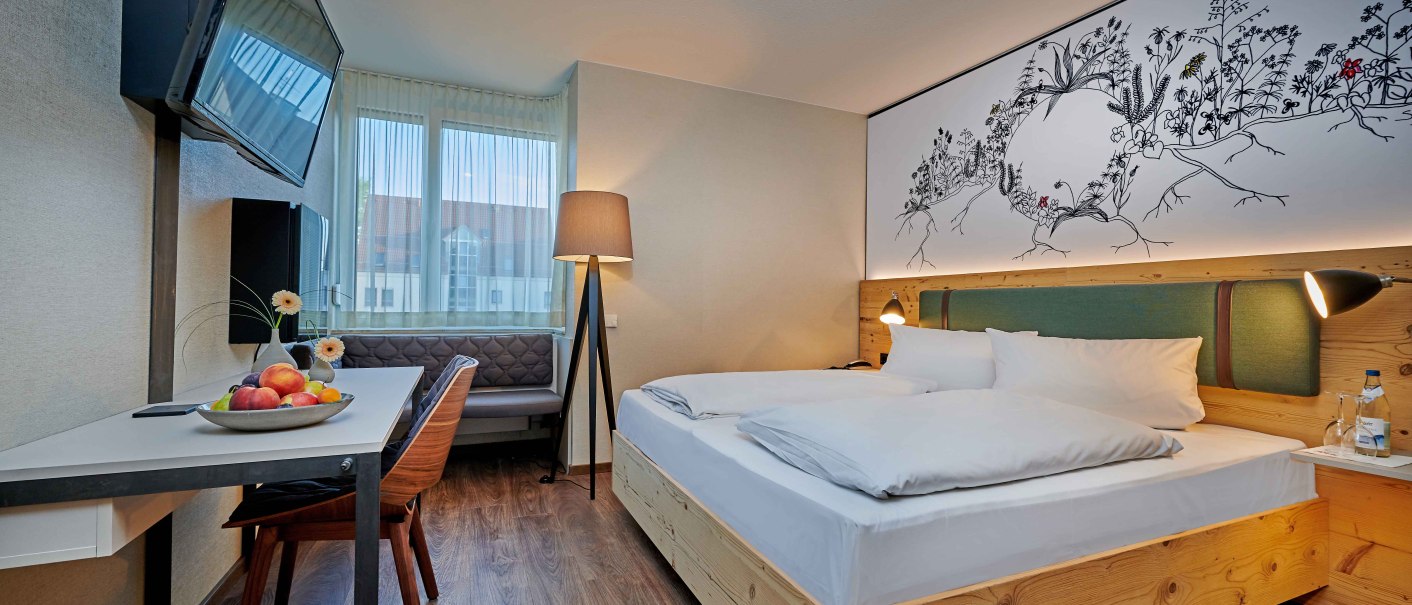 Modern double room with wooden floor, double bed, desk, TV and decorative wall art. Windows with curtains and cozy lighting., © Hotel Gasthof Hasen Modern double room with wooden floor, double bed, desk, TV and decorative wall art. Windows with curtains and cozy lighting., © Hotel Gasthof Hasen