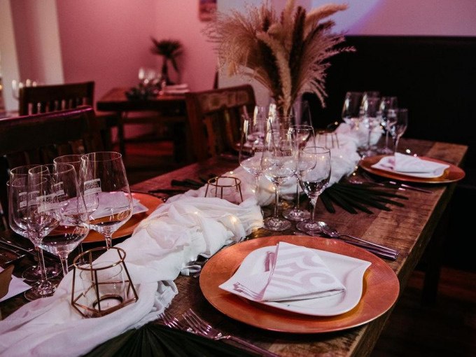 Elegant table decoration with golden plates, glasses and white napkins. Pampas grass in the center, warm light in the background., © Cool-Tours StattReisen Elegant table decoration with golden plates, glasses and white napkins. Pampas grass in the center, warm light in the background., © Cool-Tours StattReisen